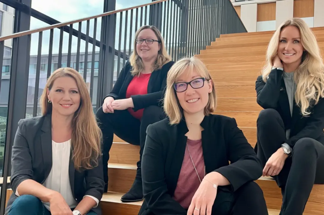 Unsere vier Recruiterinnen sitzen auf einer Treppe