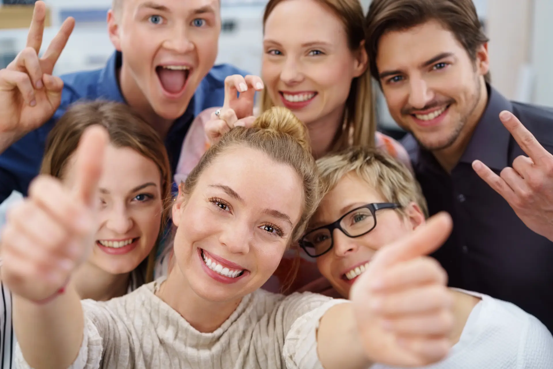 Viele junge Menschen, die den Betrachter fröhlich ansehen