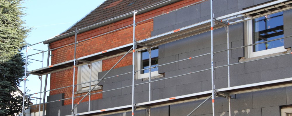 Anbringen einer Wärmedämmung an einem alten Haus.