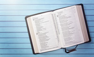 aufgeschlagene Bibel auf einem Holztisch.