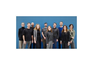 Gruppen-Teamfoto Captain T Cell GmbH vor hellblauen Hintergrund v.l.n.r. Michaela Naschke, Julian Clauß, Inan Edes, Nicole Grieger, Alberto Sada Japp, Gabriela Hernández Reina, Rainer Stahn, Felix Lorenz, Janna Hachmann, Nicole Nussbaum.