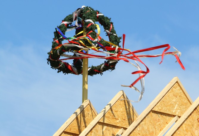 Nahaufnahme eines Dachstuhls. Ein Richtkranz ist zu sehen.