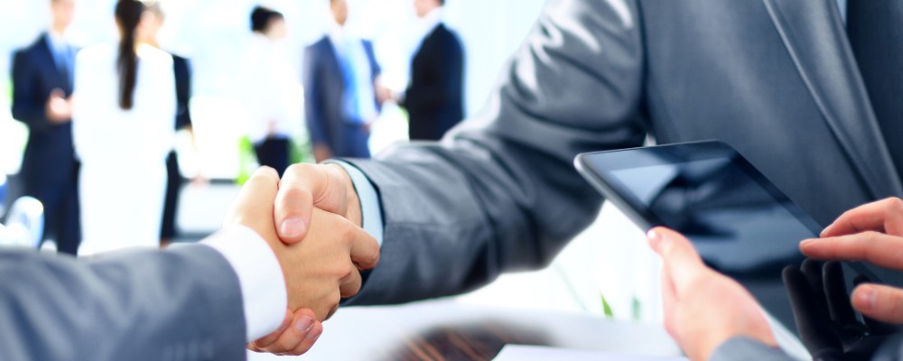 Zwei Menschen geben sich die Hand